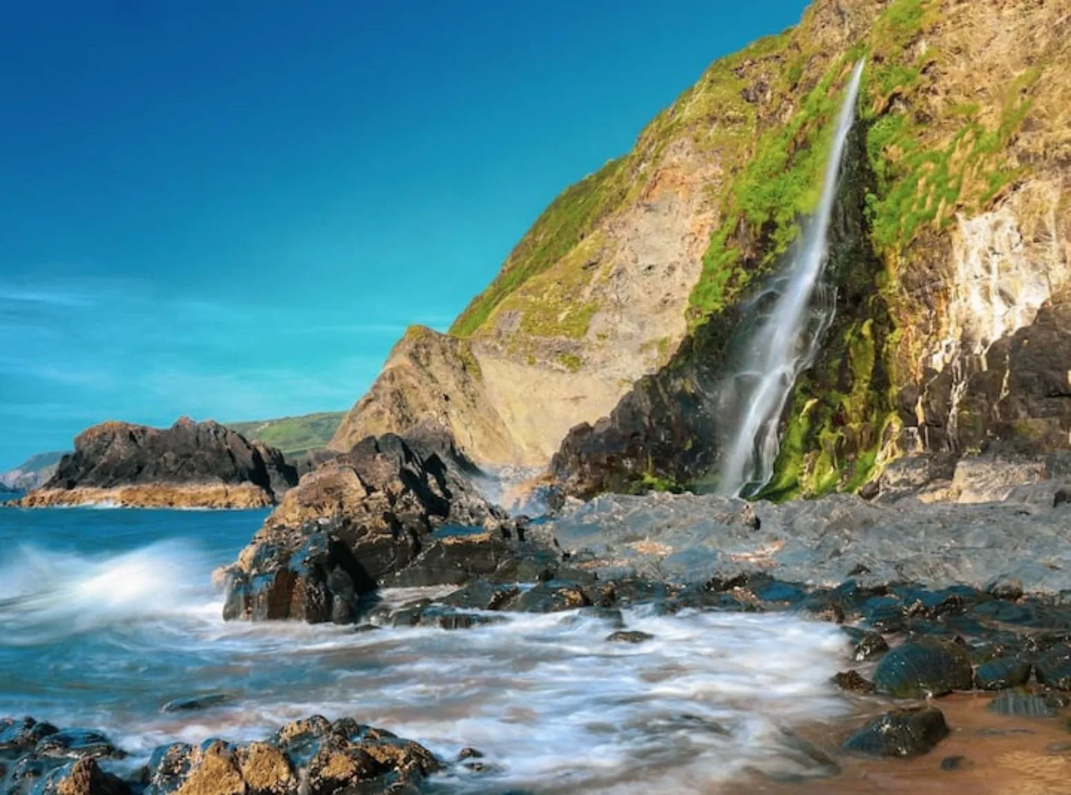 Coast path through green headland scenery around Cardigan Bay